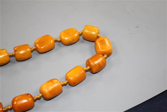 A single strand barrel shaped amber bead necklace, 86cm.